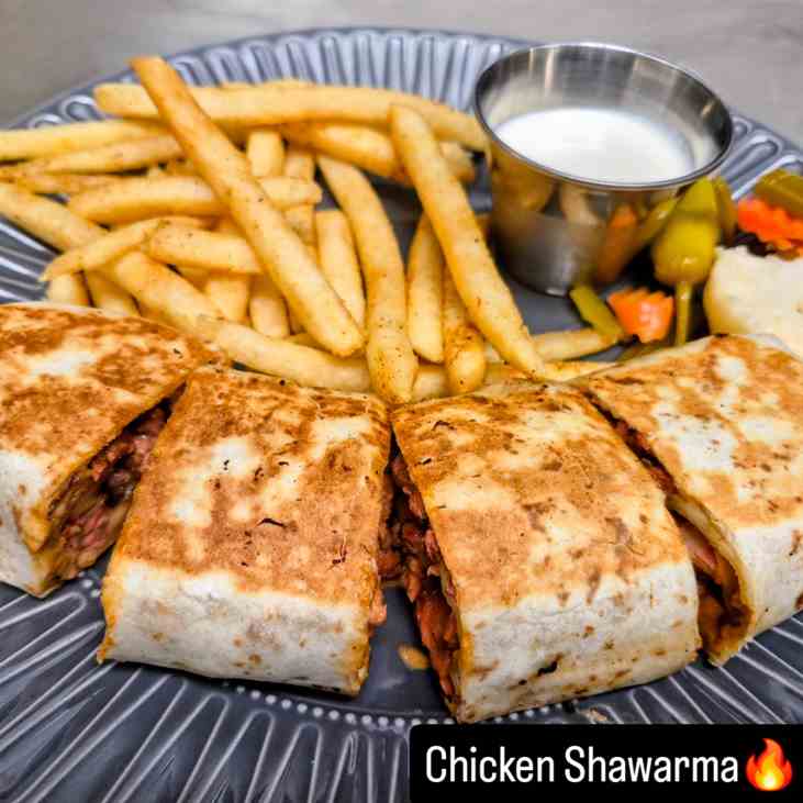 Chicken shawarma wrap sliced with seasoned fries and garlic sauce