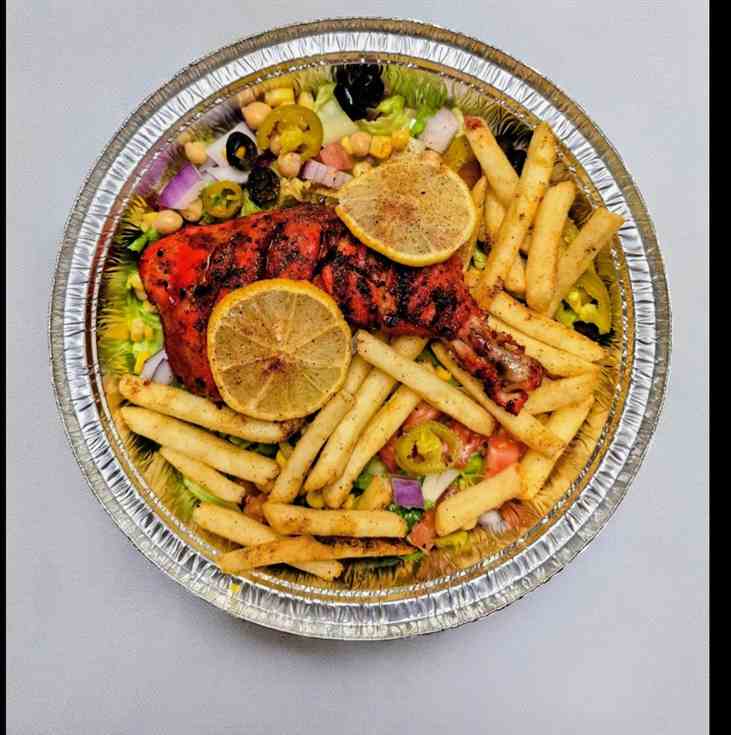 Fire-grilled chicken with fries, lemon and fresh salad at Gyro 9